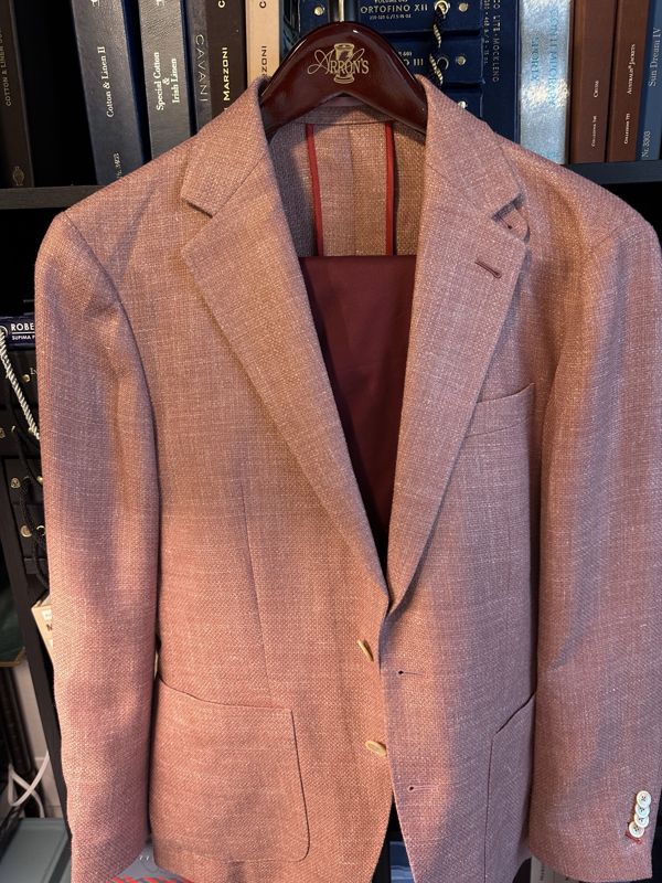 Textured rose sport coat with patch pockets and a deep red lining at the collar